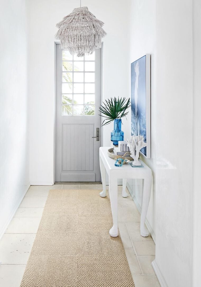 White and light-filled foyer with runner made of Suit Yourself in Flax.